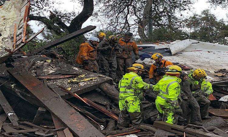 Firefighters-help-a-14-year-old-girl-leave-the-site-of-mudslide-in-Montecito