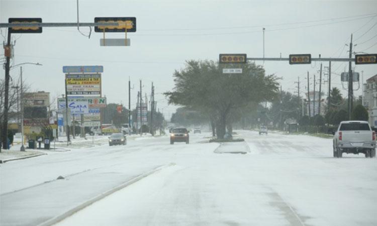Vehicles-move-on-a-snow-capped-road-in-Houston