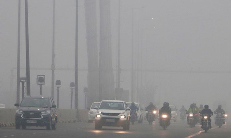 Vehicles-ply-on-a-road-amid-low-visibility-due-to-a-thick-layer-of-fog-on-a-cold-winter-morning-at-Signature-bridge