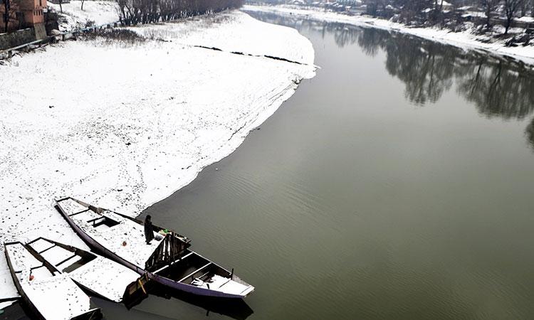 Boats-anchored-along-the-bank-of-Jhelum-river-as-the-area-covered-in-a-thick-blanket-of-snow