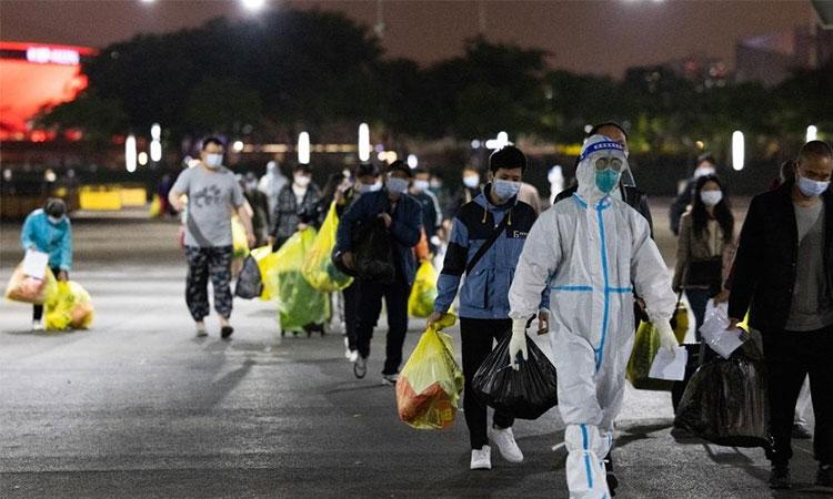 A-medical-worker-leads-recovered-COVID-19-patients-leaving-a-makeshift-hospital-in-Shanghai