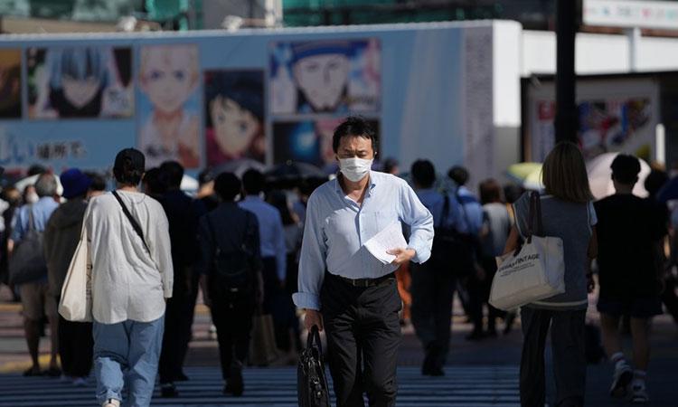 People-wearing-face-masks-walk-on-a-street-in-Tokyo-Japan.