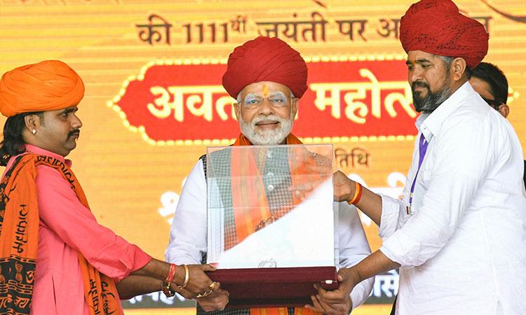 Prime-Minister-Narendra-Modi-being-presented-a-memento-during-the-commemorating-ceremony-of-1111th-Avataran-Mahotsav